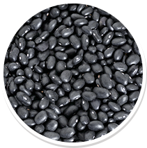 Bowl of black beans on a dark background.